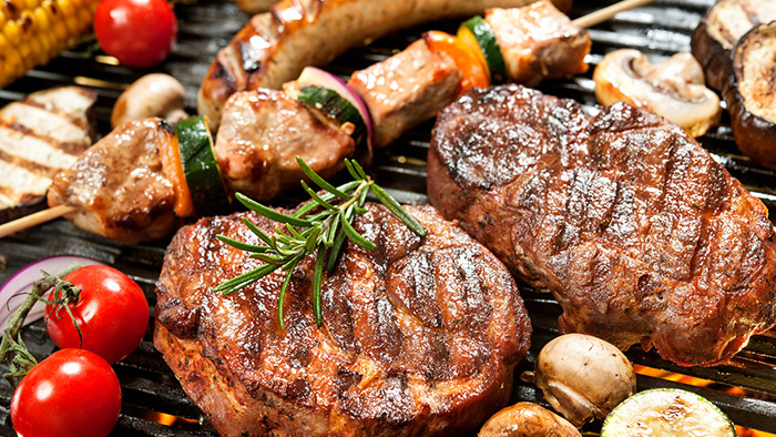 Grilled steaks and skewers cooking on a barbecue