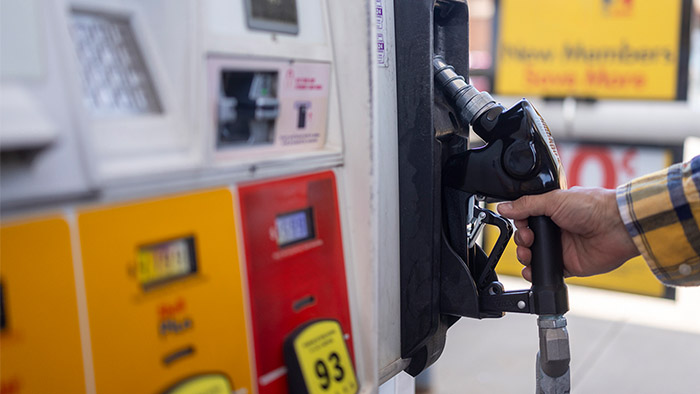 Close up of a hand grasping nozzle at gas pump